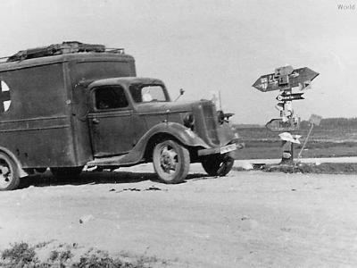 Medical V8-51 passing signpost on Russian road