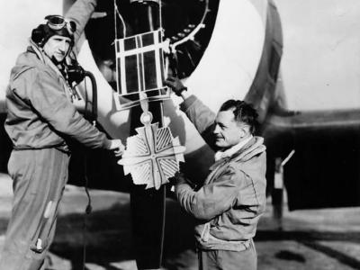 Ace Norman Olson hangs replica DFC on P-47 Thunderbolt from 357th Fighter Squadron, 355th Fighter Group
