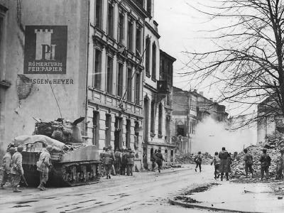 3rd Army soldiers advance with M4 Sherman tank toward Cathedral in Cologne Germany 1945