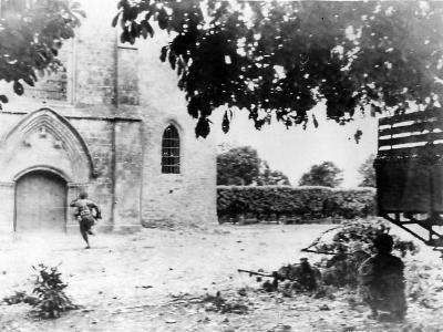 Airborne Trooper runs for sniper hiding in Church in St. Mere Eglise