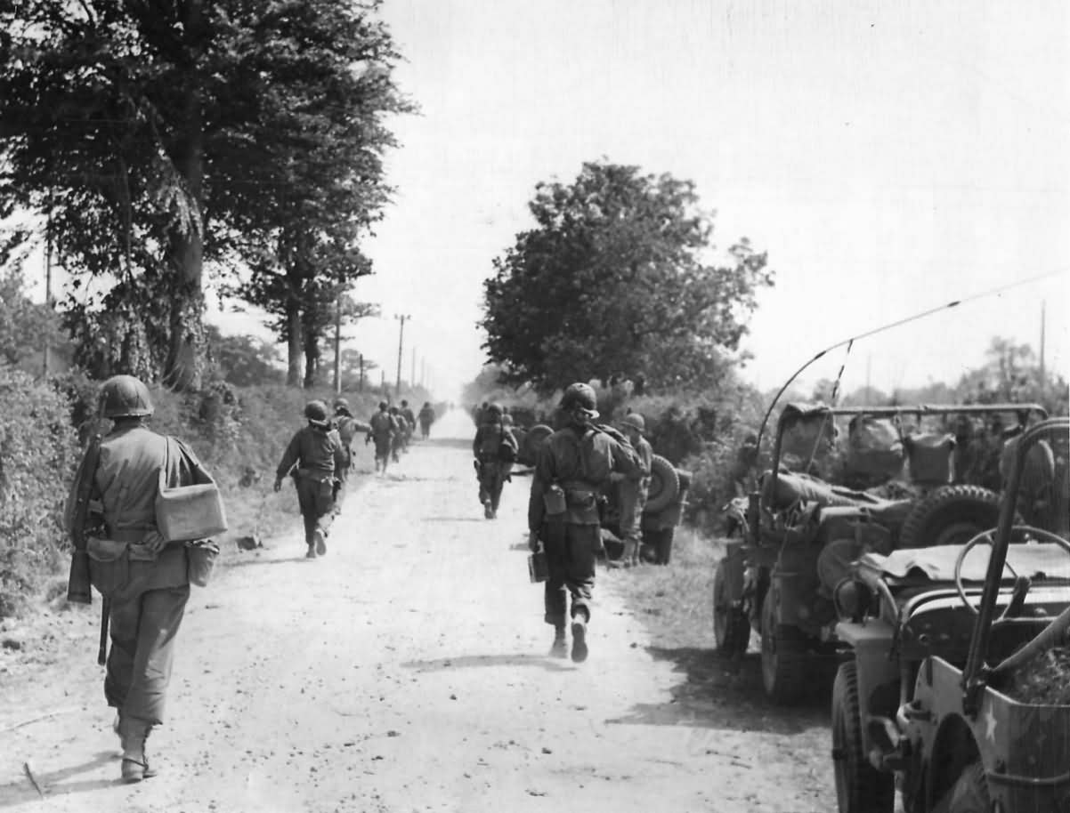 American Soldiers Advancing Past Jeeps on Road to Cherbourg France 30 June 1944