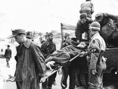 German Prisoners Unload Wounded Comrade on Normandy Beachhead 1944
