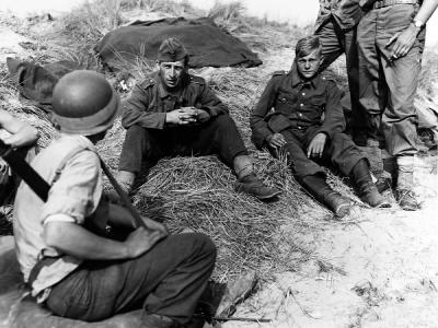 Polish prisoner in German uniform is interrogated by US soldiers 15 June 1944