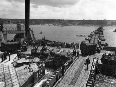 Supplies flow over Mulberry B Harbor at Gold Beach Arromanches