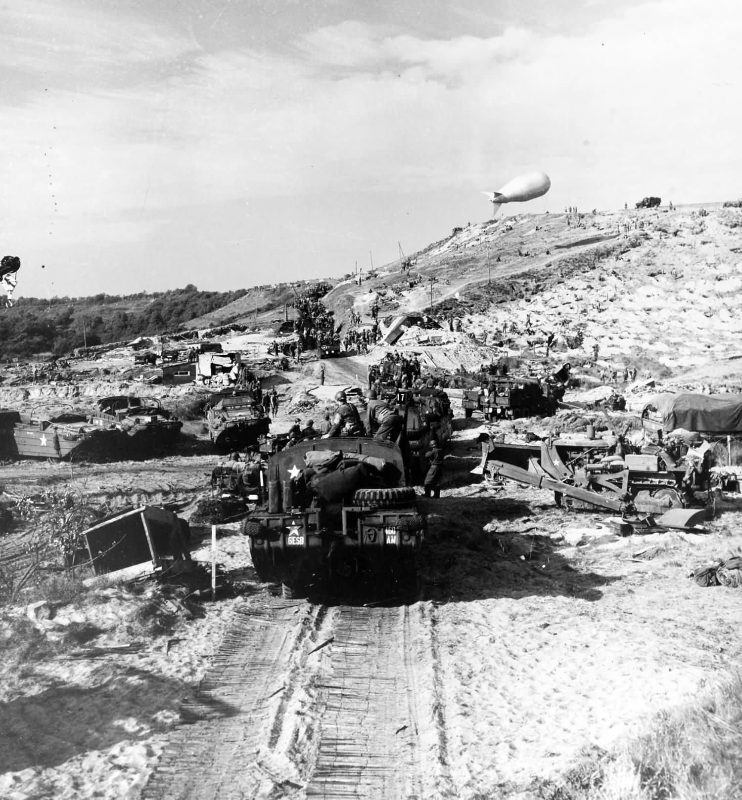 US Army vehicles move inland from a Normandy invasion beach