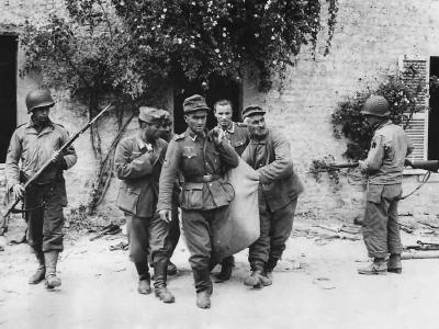 US Soldiers guard German POW leaving hideout in Normandy 1944