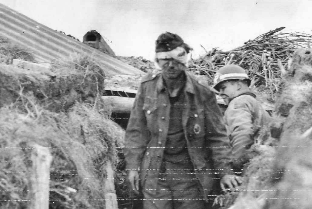Wounded German Prisoner with MP of 1st ESB 449th MP Co in Normandy