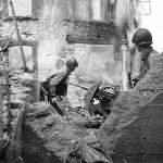 US soldiers hunt for a Germans in a shell torn building in Cherbourg France 1944
