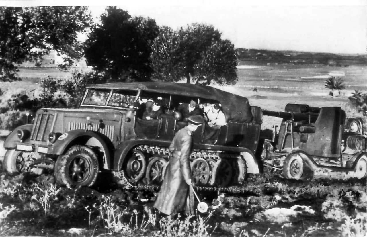 German troops use Sd Kfz 7 to tow Flak 18 gun up a hill