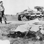 US soldier between Panzerwerfer 42 and fallen German soldier 1944