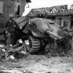 Soldier inspecting destroyed Hetzer