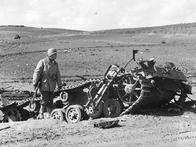 US soldier examines the wreckage of a Panzer III which was ko in battle at Kasserine Pass 1943