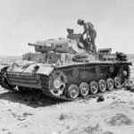 A destroyed Panzer III tank being inspected near Tel el Eissa 4 August 1942