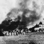 Crusader tank passing a burning Panzer IV during Operation Crusader in Libya 1941