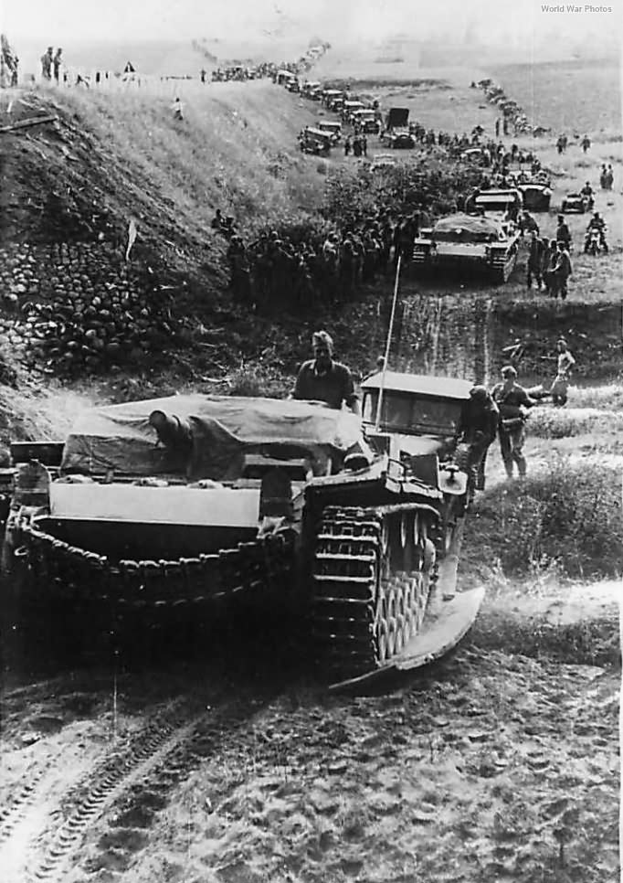 StuG III leading a long column of troops and vehicles somewhere on the Eastern Front