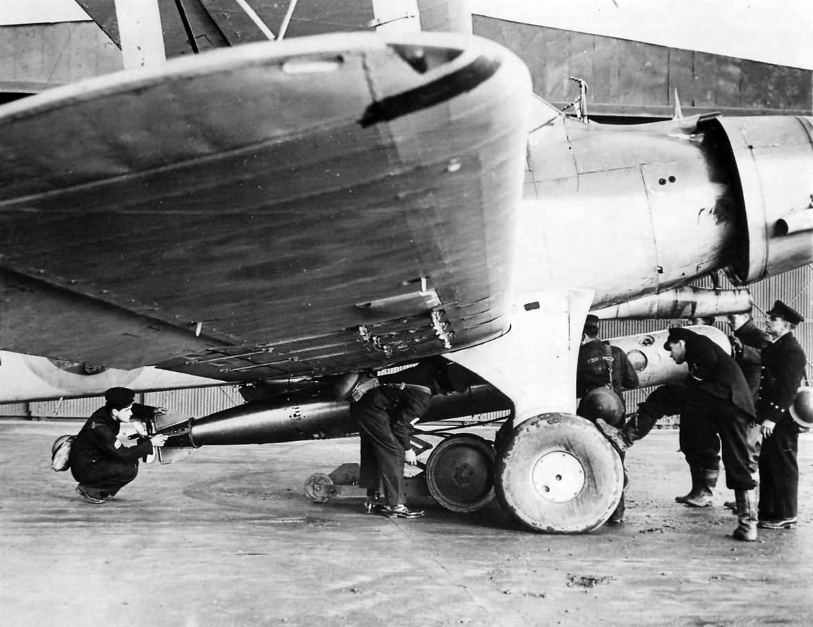 FAA pilot supervises loading of torpedo on his Albacore