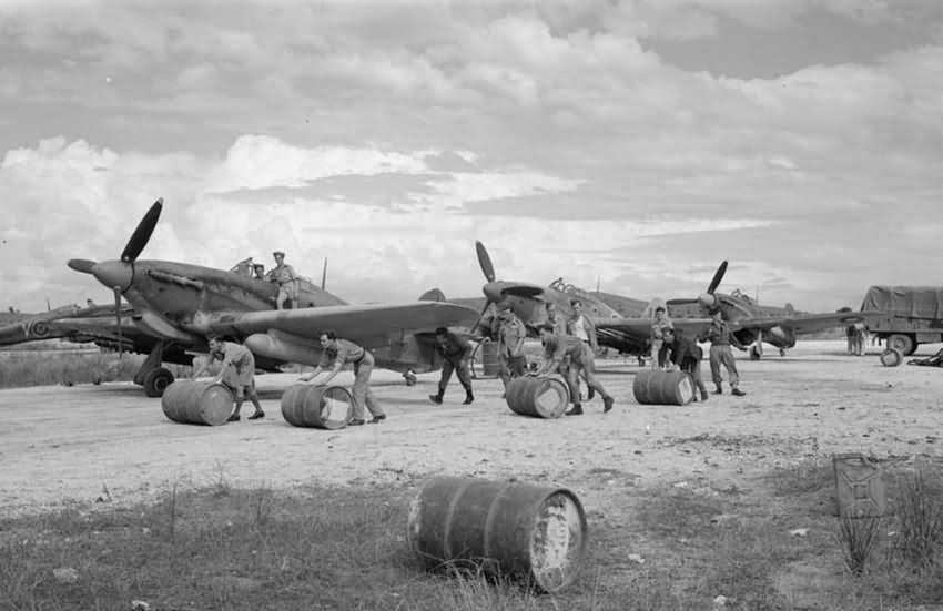 Ground crew rolling drums of petrol to Hurricane Mk IV of No 6 Squadron RAF at Araxos Greece