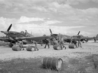Ground crew rolling drums of petrol to Hurricane Mk IV of No 6 Squadron RAF at Araxos Greece