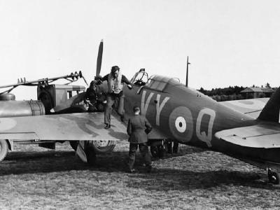 Sqn Ldr Peter Townsend jumps down from Hurricane Mk I P3166 VY-Q No 85 Squadron while being refuelled at Castle Camps July 1940