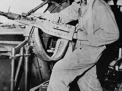 Waist gunner readying his M2 Browning machine gun aboard Boeing B-17