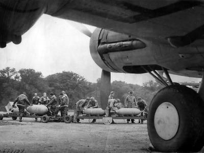 Pilot chalks message on bomb as crewmen load B-17, England 1942