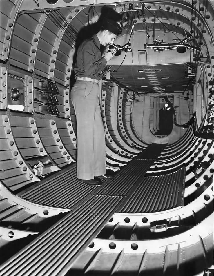 Lieutenant pictured talking on the phone in rear section of the fuselage of a Douglas XB-19