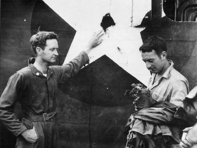 Major Richard Craig inspects hole in his B-24 made by A6M during raid on Gastmata New Britain 1943