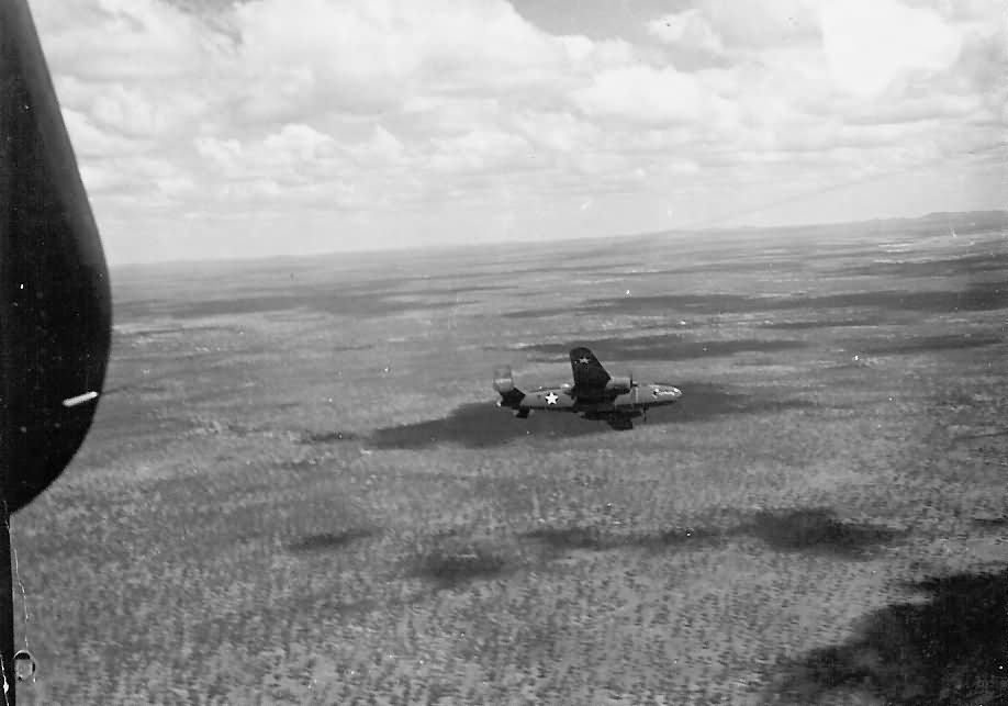 B-25 Mitchell bomber in flight over jungle during World War II