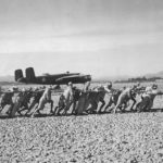 Chinese Troops pull roller past B-25 to smooth airstrip in China 1943