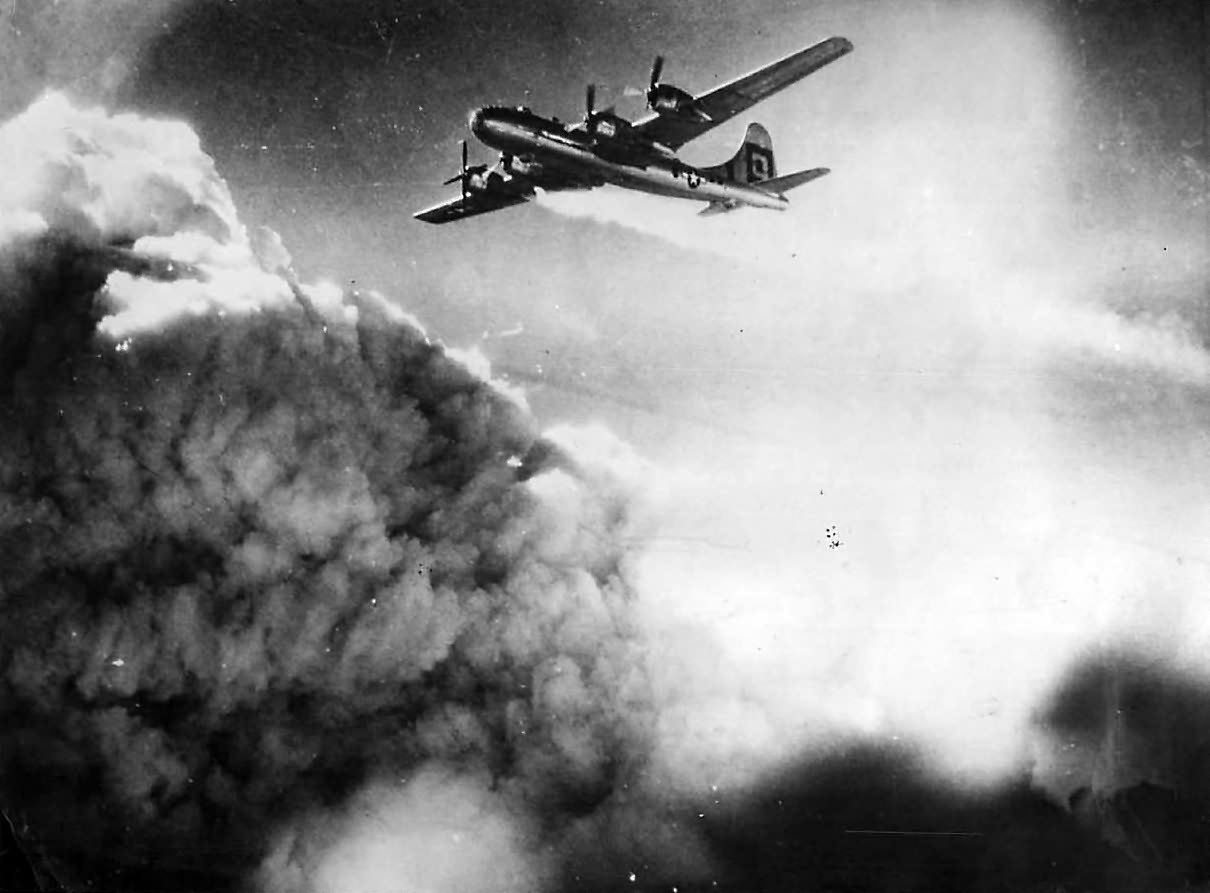 Flames trail engine of B-29 over Kobe, July 1945
