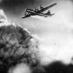 Flames trail engine of B-29 over Kobe, July 1945