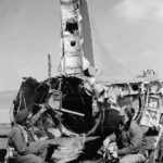 398th BG Airmen look at shot up B-17 44-8811