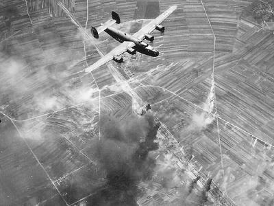 15th Air Force B-24 passing over burning target