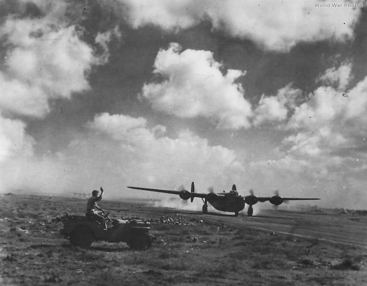 Airman in Jeep Waves to 9th AF B-24 taking off in North Africa