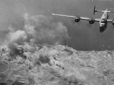 B-24 leaving target burning below