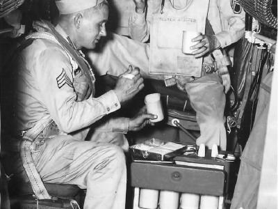 Crewmen dine from food tray galley aboard B-29