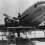 Sailors at work on the engine of an R4D