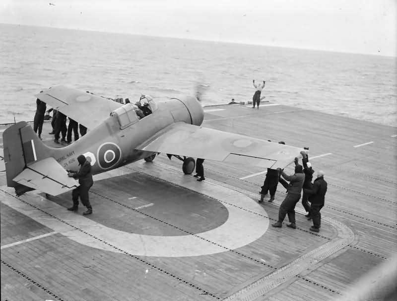 Grumman Wildcat fighter of No 882 Squadron Fleet Air Arm being manoeuvred into position for takeoff from HMS PURSUER off the northern coast of Norway