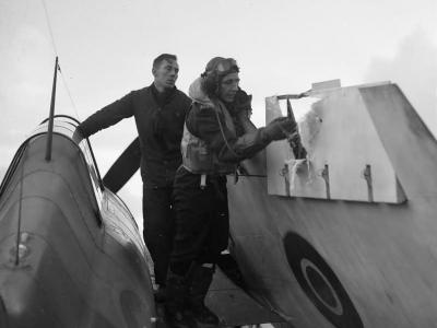 Pilot examining flak damage to aileron of his Wildcat December 1944