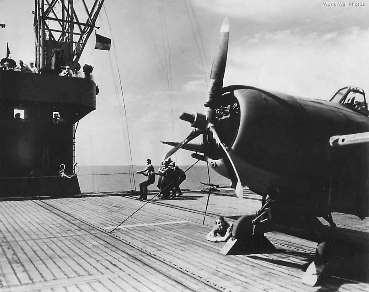 Crew starts F4F using boot and shock cord aboard USS Charger