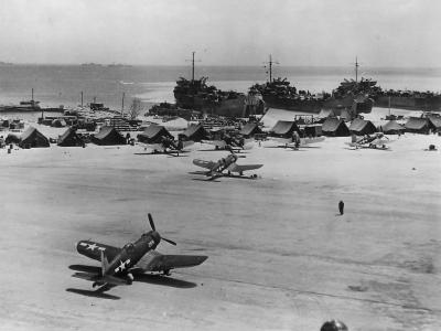 Corsairs on runway and LSTs on Beach at a Marshall Islands Base 1944