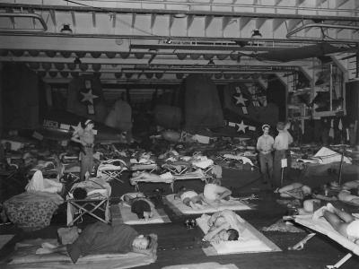 Marine fighter pilots sleep on hanger deck of USS Santee with F4U 1944