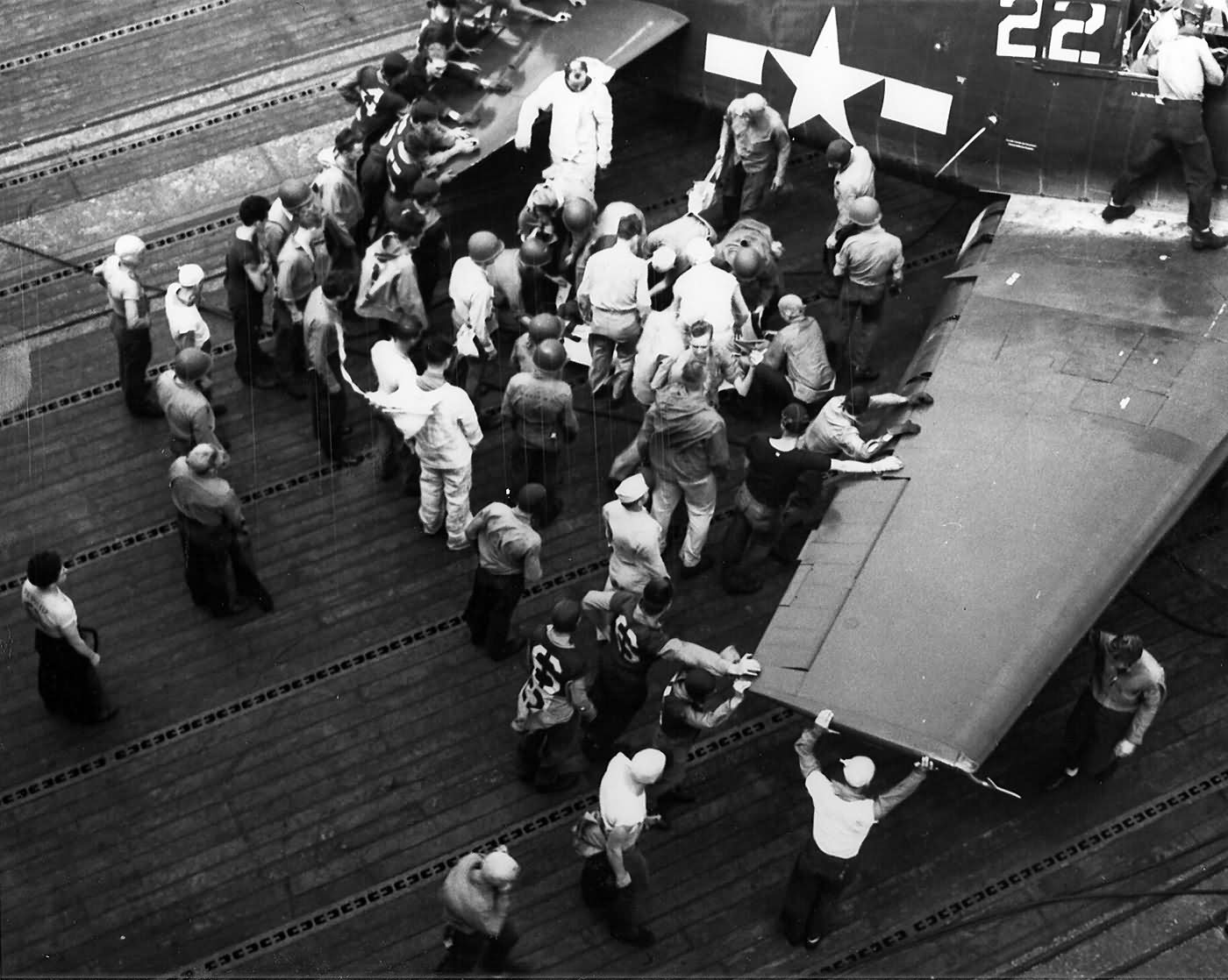 Flight deck personnel attend to a wounded pilot of VF-19. F6F-5 Hellcat #22 USS Lexington CV-16 – Battle of Leyte Gulf, October 24, 1944