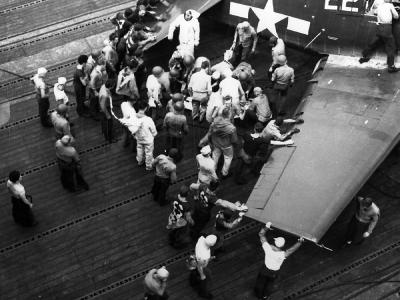 Flight deck personnel attend to a wounded pilot of VF-19. F6F-5 Hellcat #22 USS Lexington CV-16 – Battle of Leyte Gulf, October 24, 1944
