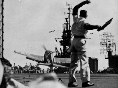 LSO on board the carrier Cowpens CVL 25 watches an F6F Hellcat of VF 25 November 20 1943