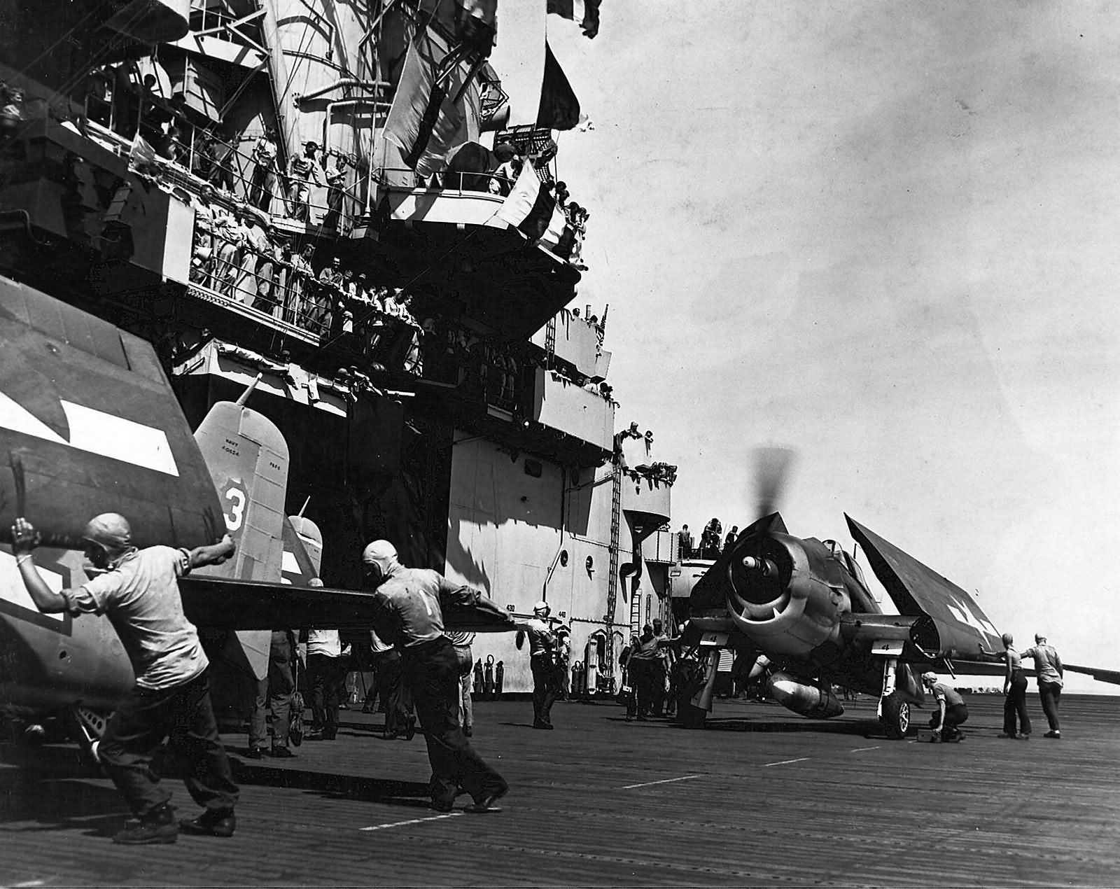 USS Essex CV-9 crew push F6F Hellcats of VF-15 forward 1944