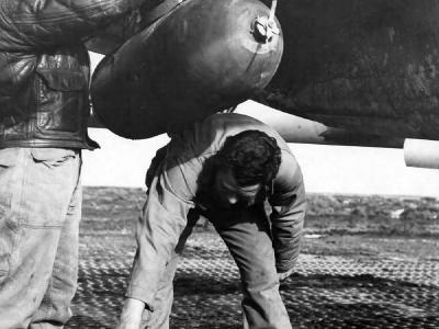 A 500 lb Bomb Is Attached Under the Wing Of A P-38 Lightning By Members Of the 94th Fighter Squadron 1st FG Italy