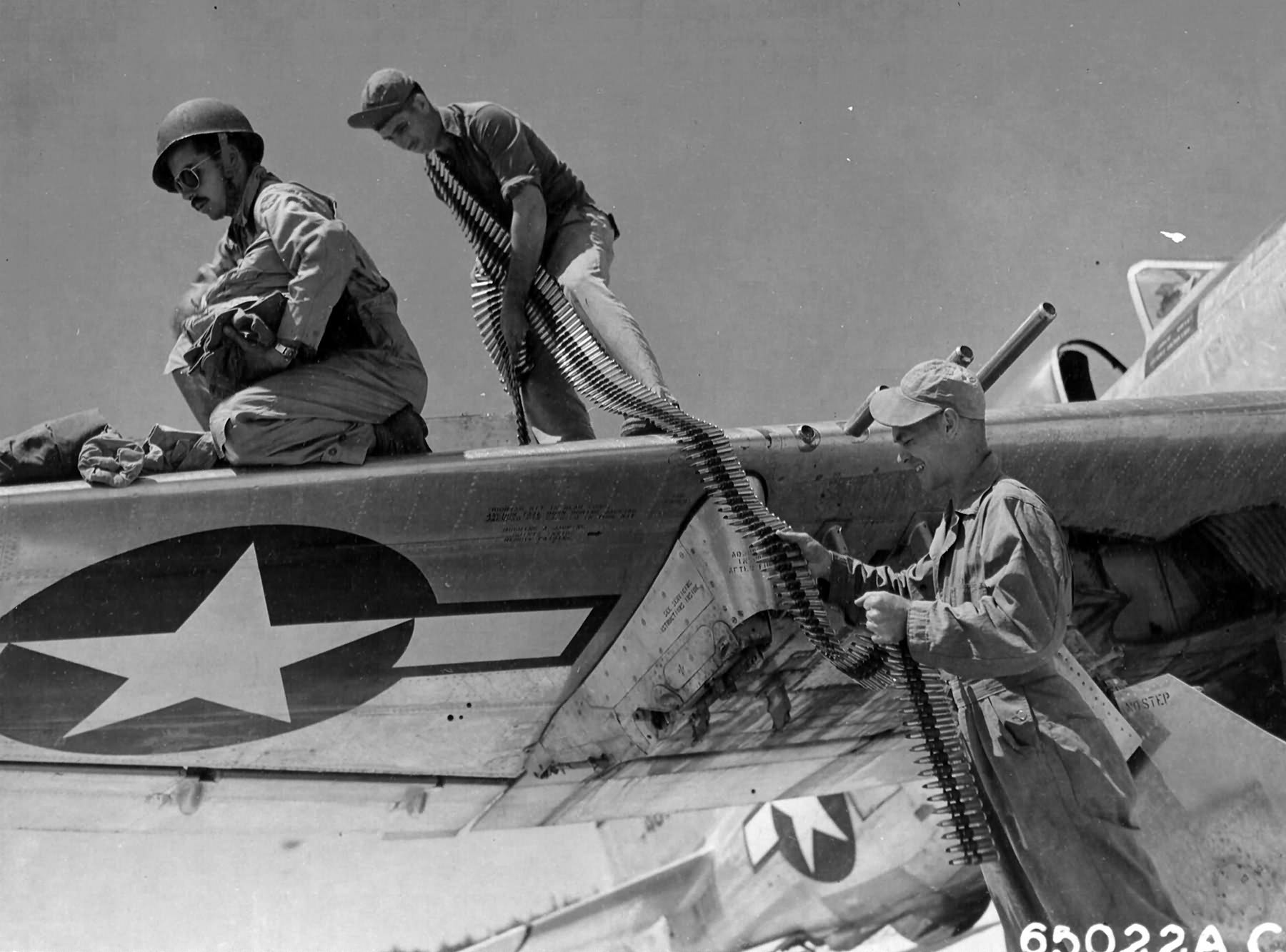Armorers removing ammo from wing guns of a P-47 Thunderbolt of the 318th FG