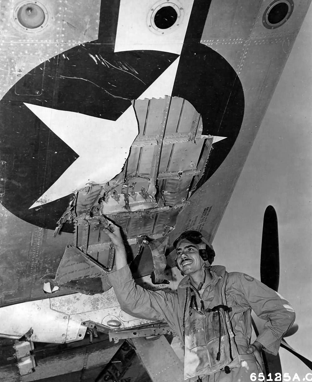 Lt John A. Dooling of 318th FG inspects hole made in the wing of his P-47 by AA fire