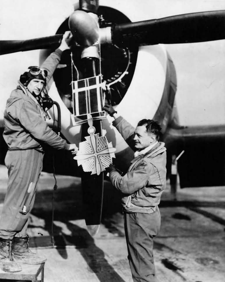 Ace Norman Olson hangs replica DFC on P-47 Thunderbolt from 357th Fighter Squadron, 355th Fighter Group